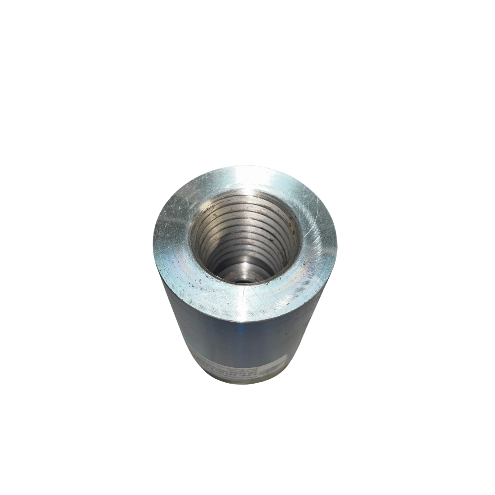 A metal nut is sitting on top of the ground.